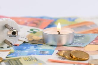a lighted candle on top of a paper money